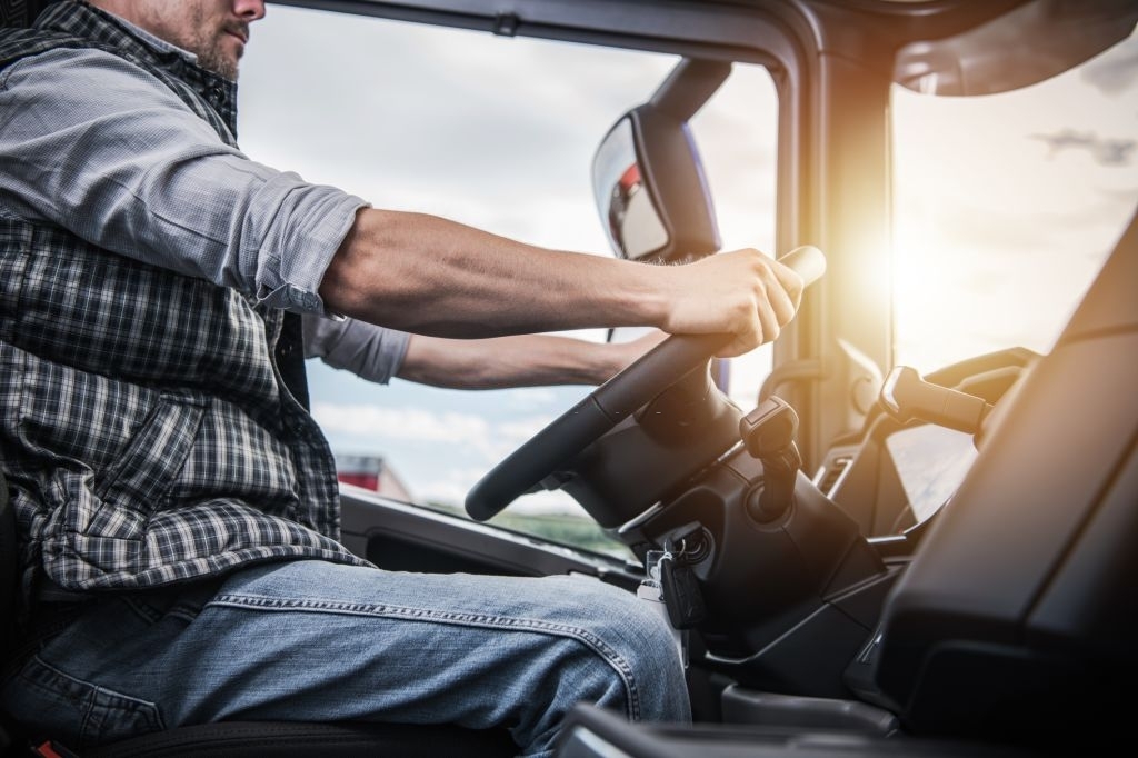 Truck Driver Behind the Wheel. Semi Truck Driving and Transportation Industry.