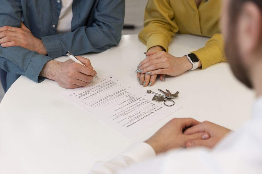 agente-imobiliario-masculino-fazendo-negocios-e-mostrando-a-casa-para-um-possivel-casal-comprador (1)