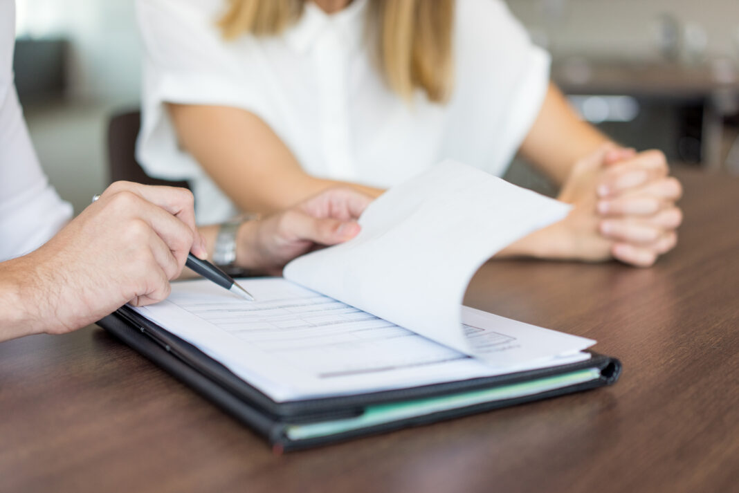 Hands of male executive showing contract to female partner