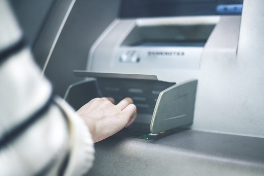 Woman using cash machine-ATM,close up view