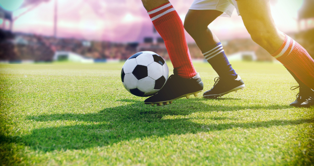 Dois jogadores disputando bola de futebol
