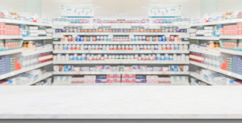 Empty white marble counter top with blur pharmacy drugstore shelves background
