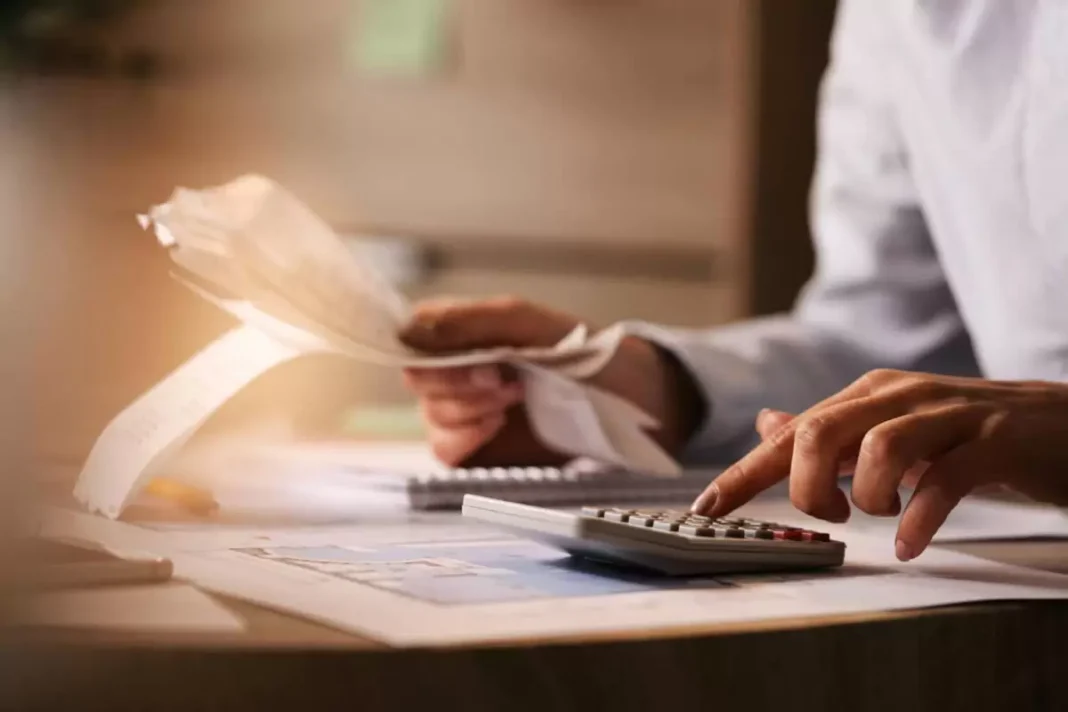 closeup-de-economista-usando-calculadora-ao-passar-por-contas-e-impostos-no-escritorio-menor
